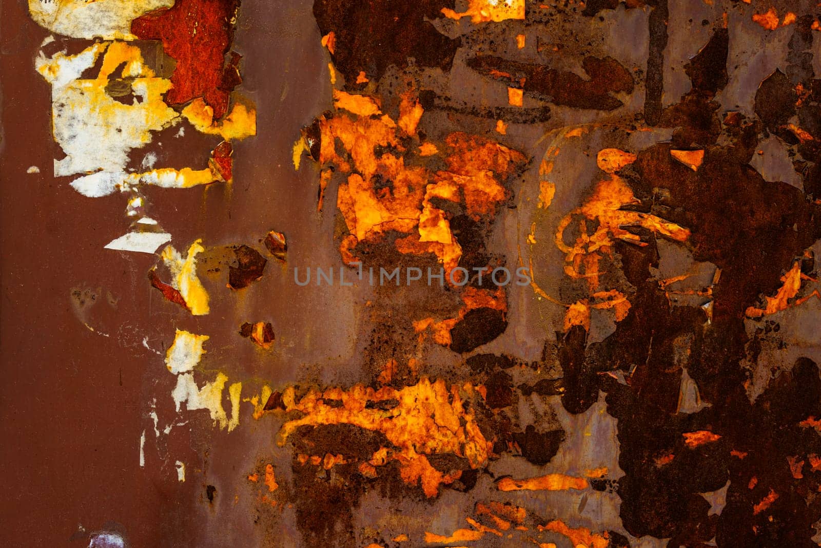 Close up of a brown rusted sheet metal surface with leftovers of peeled off paper advertisements by z1b