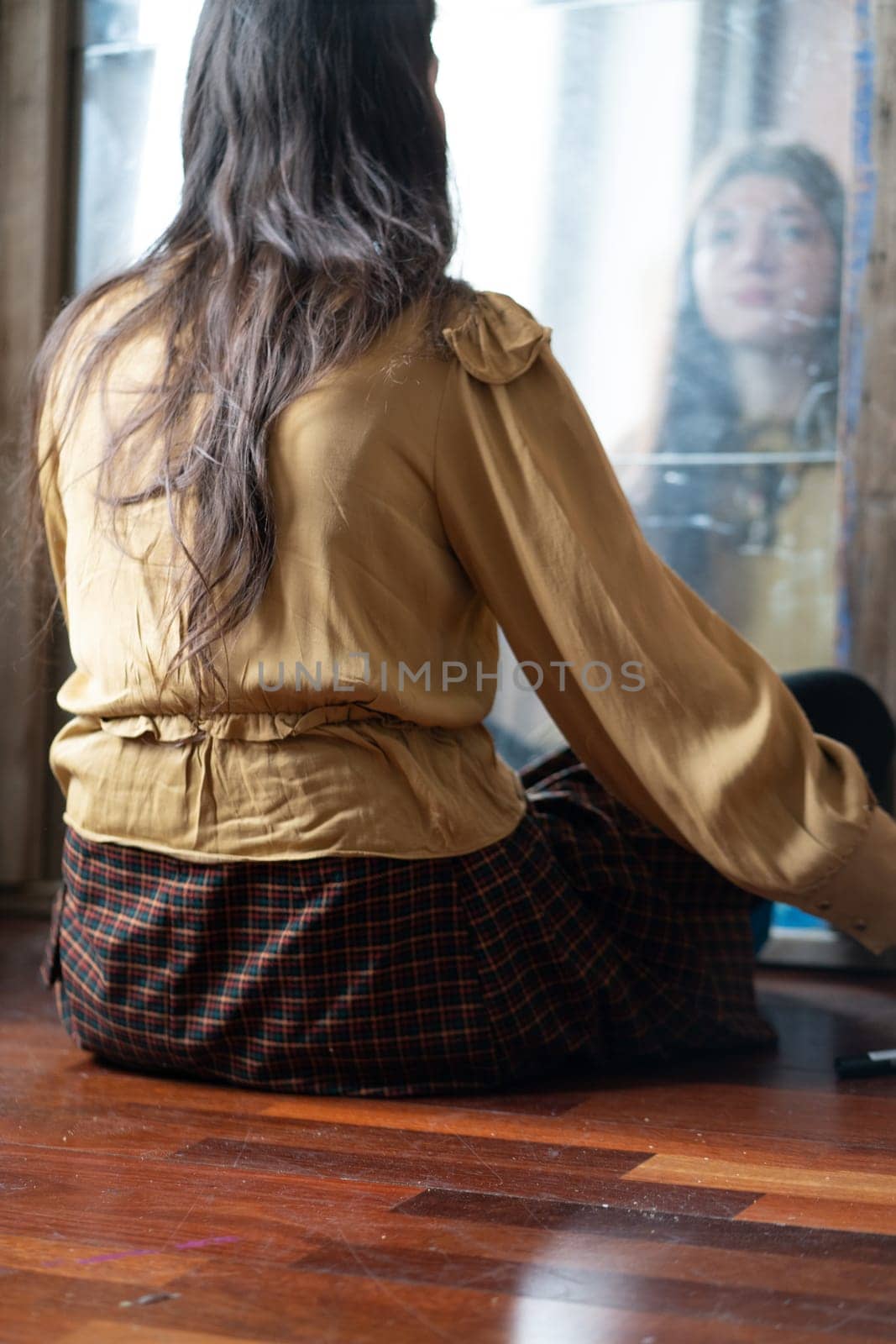 young beautiful woman applying makeup near the mirror