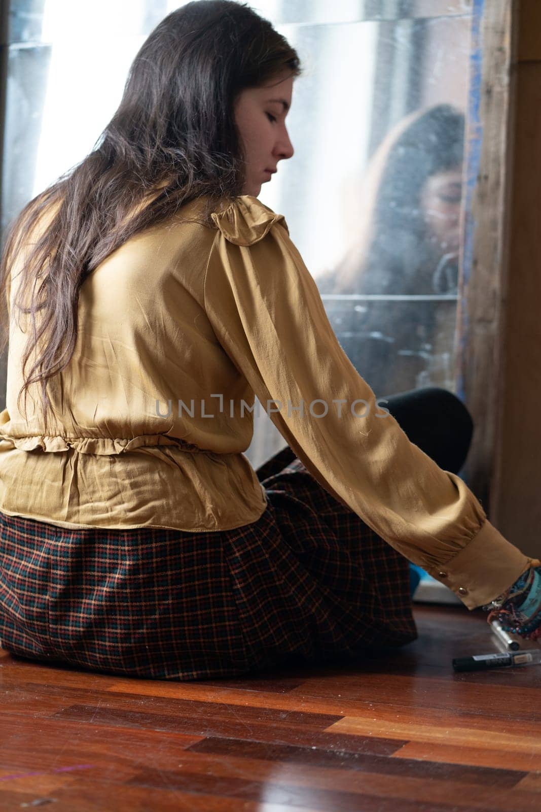 young beautiful woman applying makeup near the mirror