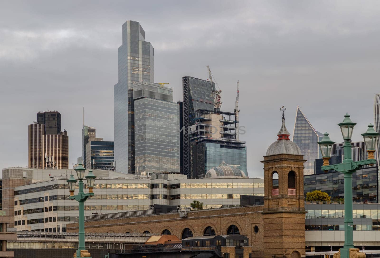 London, UK - Feb 27, 2024 - Beautiful view of Skyscrapers and The cannon street railway bridge in the business district Looking through Southwark bridge in city of london. Architectural modern buildings, Copy space, Selective Focus.