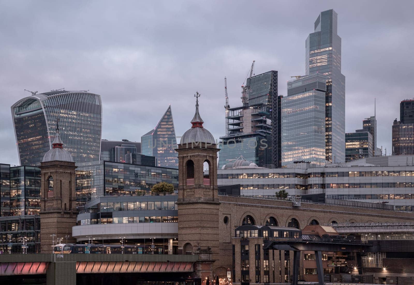 London, UK - Feb 27, 2024 - Beautiful view of Skyscrapers and The cannon street railway bridge in the business district Looking through Southwark bridge in city of london. Architectural modern buildings, Copy space, Selective Focus.