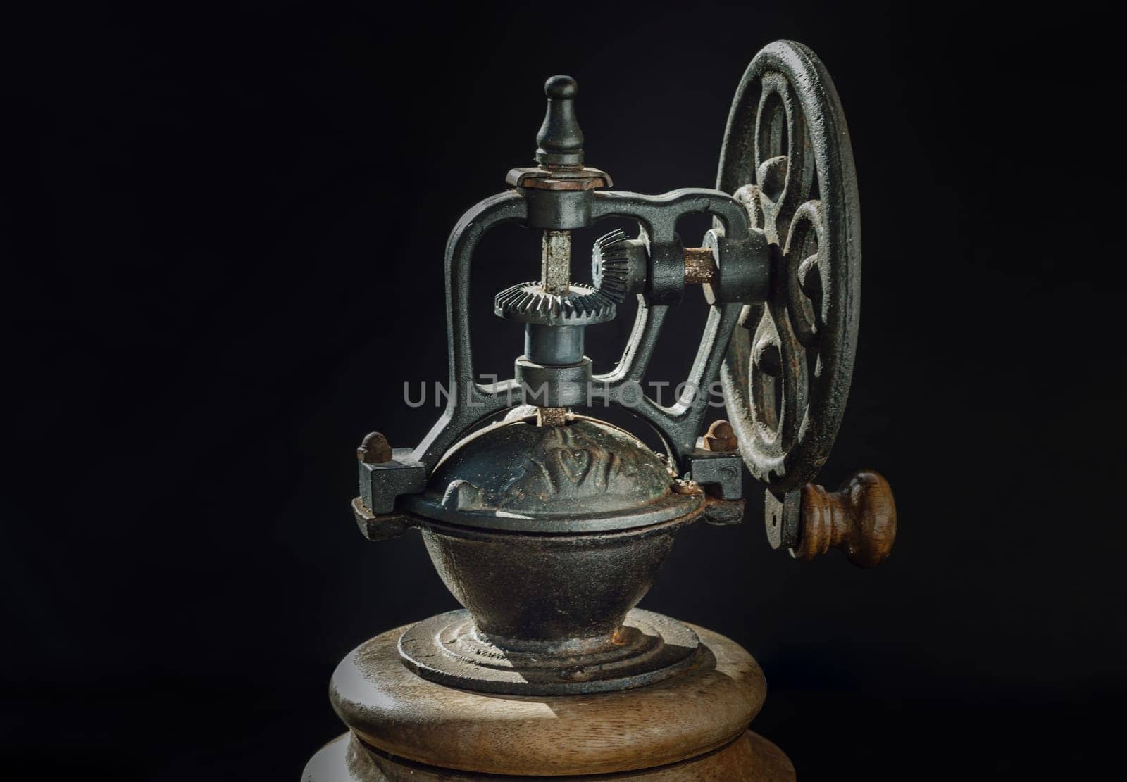 Detail of Old original coffee grinder metal shake wheel with hand crank on dark background. Close-up of Antique coffee bean original grinder, Copy space, Selective focus.