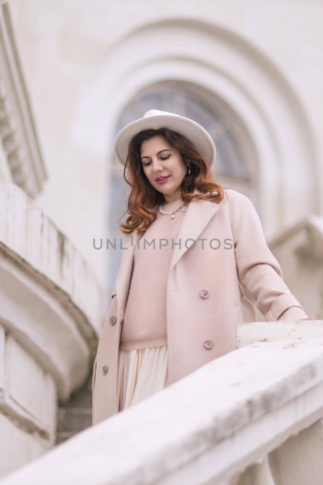 woman in elegant attire against an intricate architectural backdrop, harmoniously blending modern fashion with historical allure. The soft daylight adds to its timeless appeal. by Matiunina