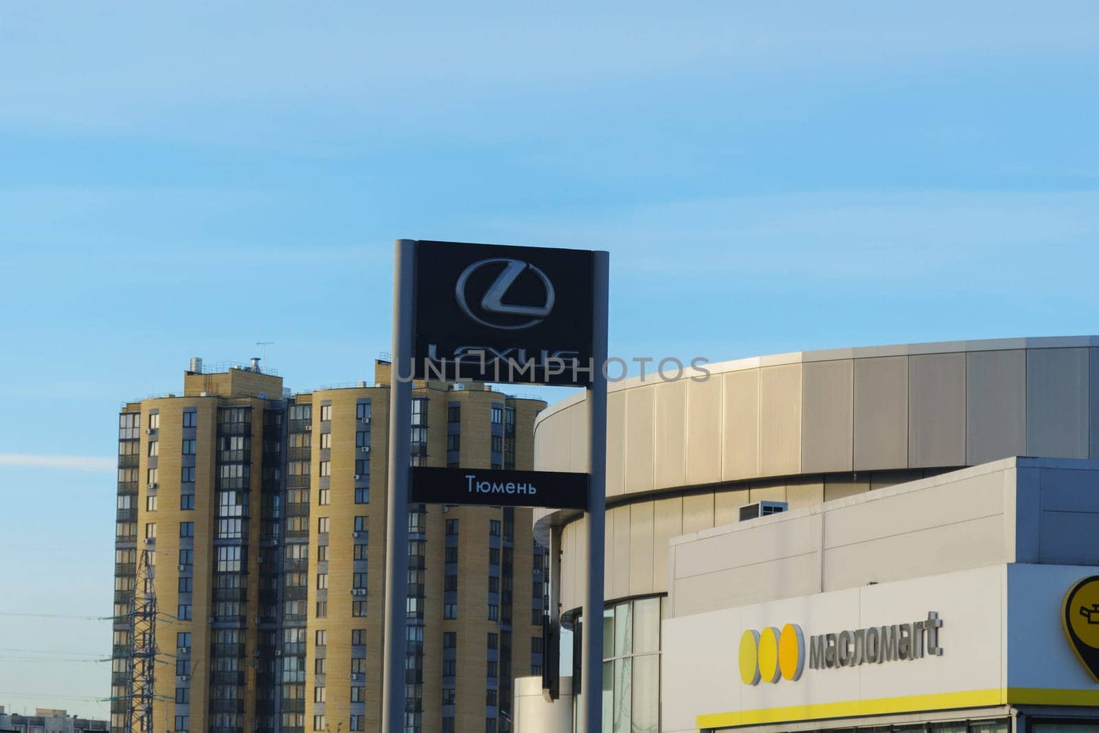 Tyumen, Russia-March 18, 2024: Sign displaying the Lexus logo for a car dealership stands prominently in front of a building. by darksoul72