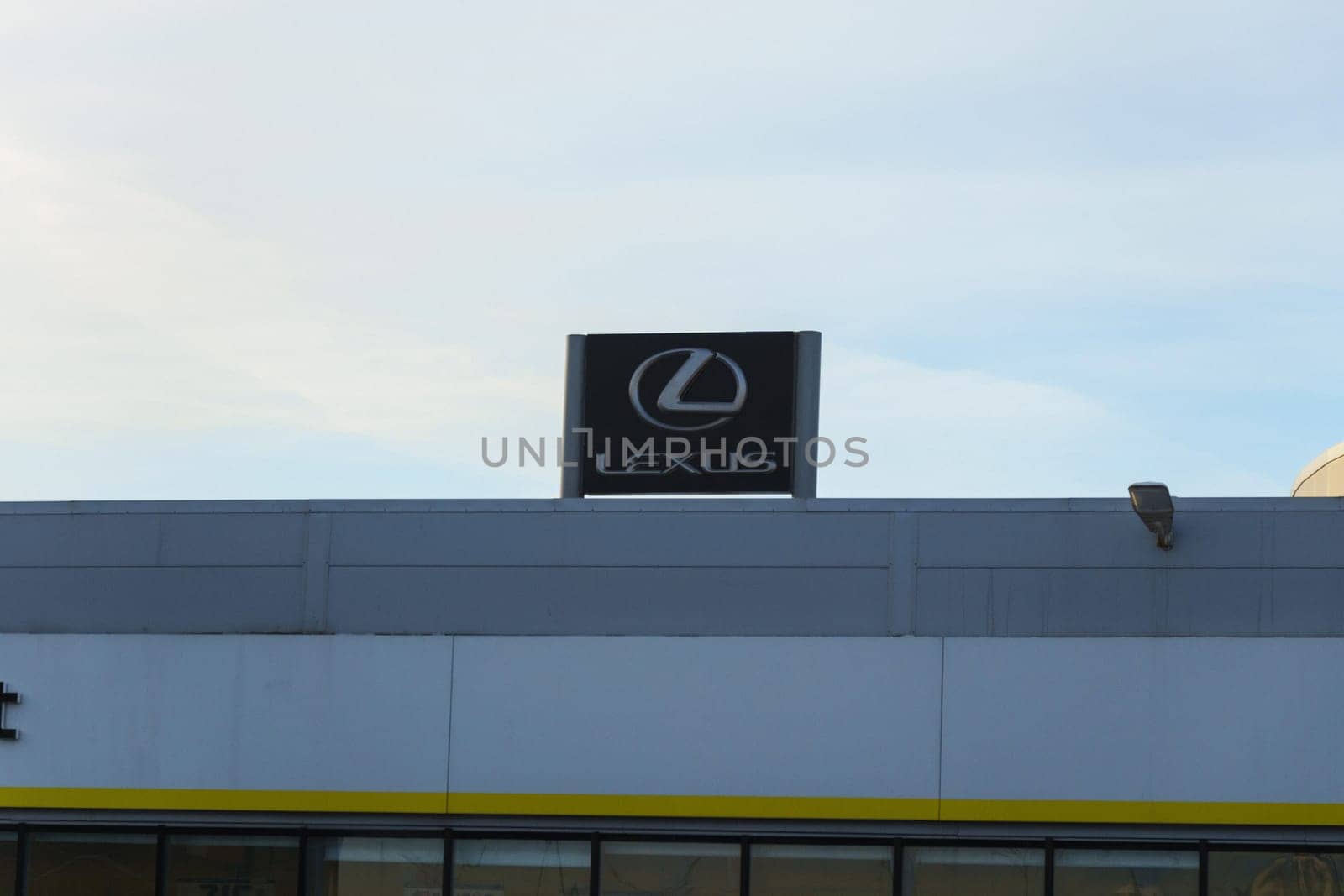 Tyumen, Russia-March 18, 2024: Sign displaying the Lexus logo for a car dealership stands prominently in front of a building. by darksoul72