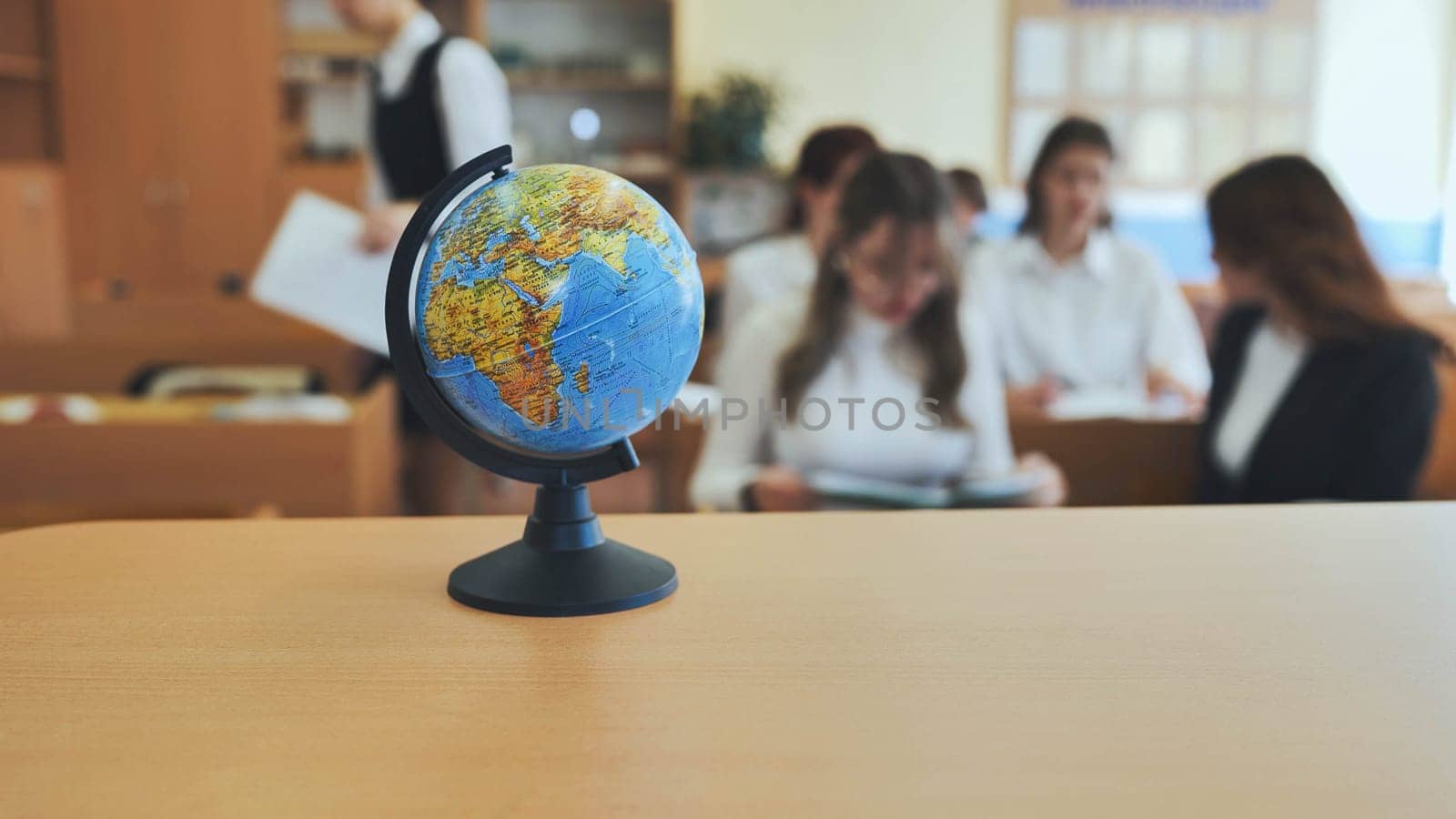 A globe of the world in a school classroom during a lesson. The globe shows Africa and Eurasia. by DovidPro