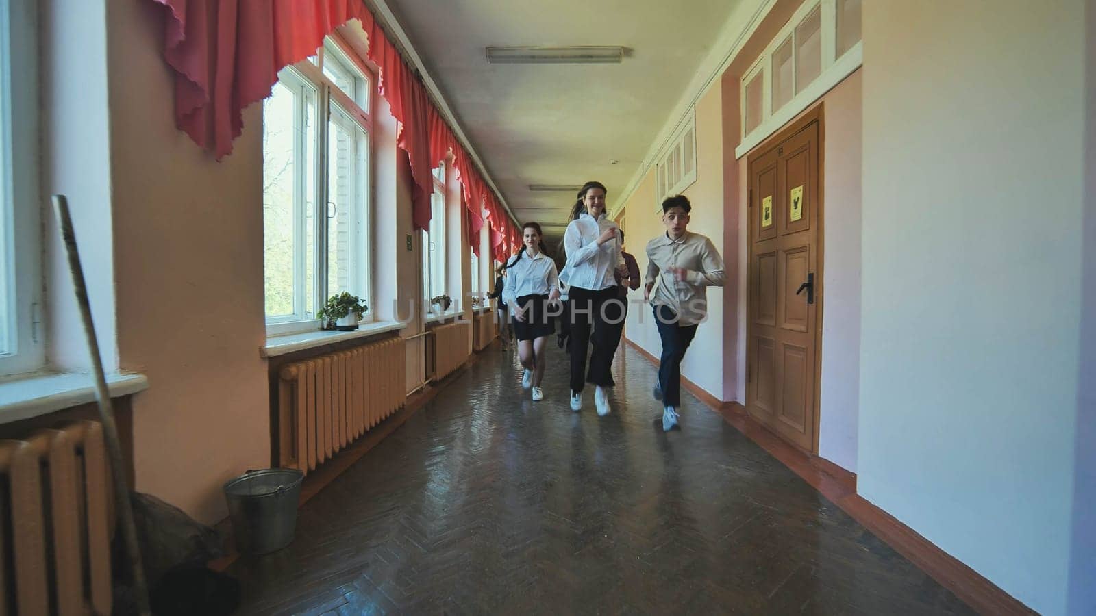 The students are running down the hallway of the school. by DovidPro
