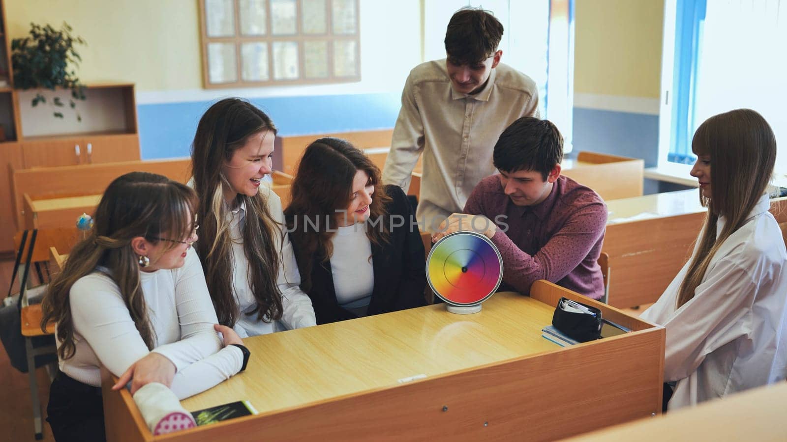 Students in physics class spin Newton's multicolored disk