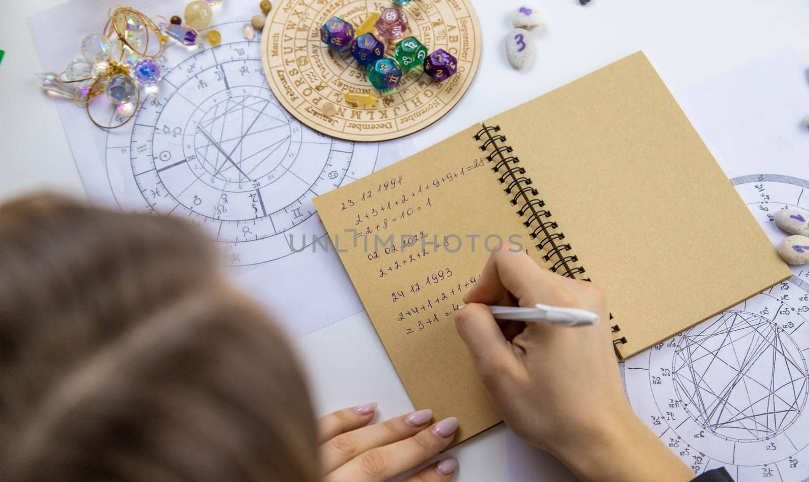 Woman numerologist astrologer counts numbers. Selective focus. People.
