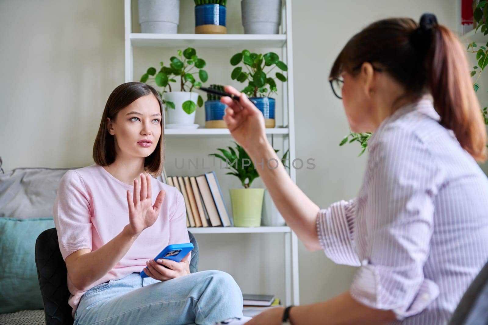 Young woman patient at meeting session with female psychologist therapist social worker counselor psychotherapist. Mental health professional help support treatment psychology psychotherapy counseling