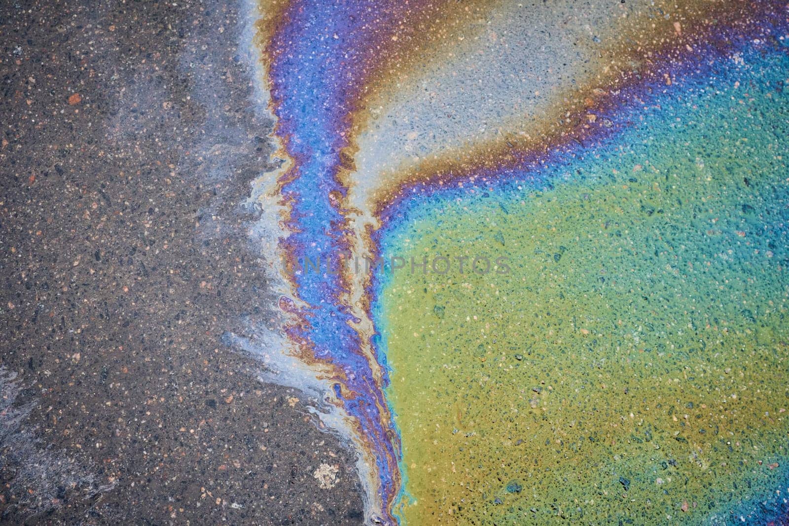 The oil left behind after rain forms spots that refract the sun's spectrum like a rainbow