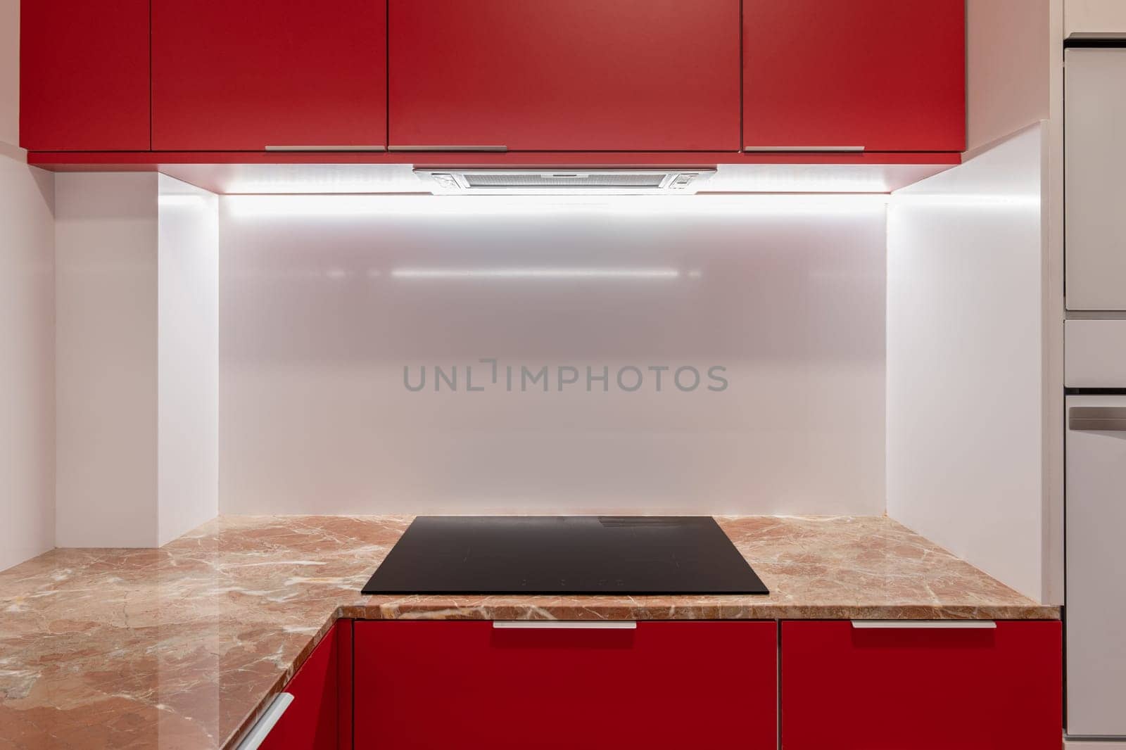A modern Kitchen With Red Cabinets And A Black Stove by apavlin