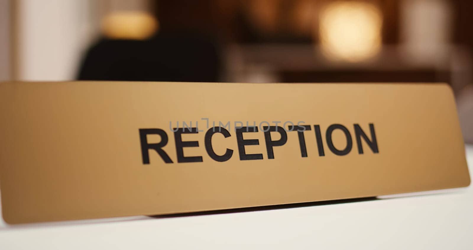 Extreme close up of luxury modern hospitality industry resort check in reception counter sign. Empty clean front desk in stylish travel accommodation resort lounge interior