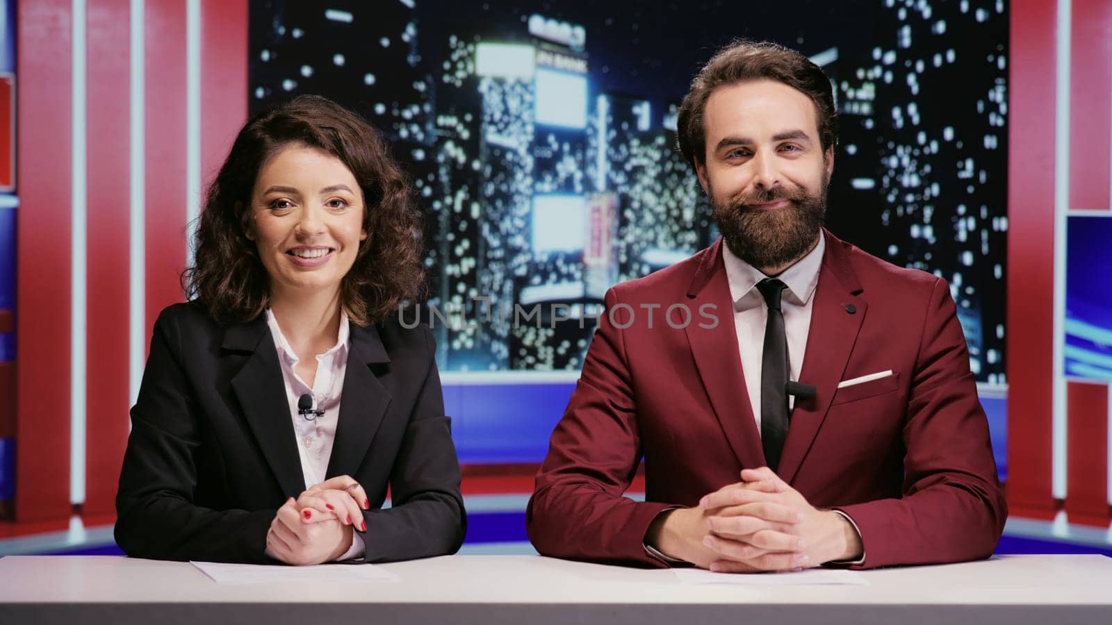 Reporters team hosting night show late to discuss about latest celebrity scandals in newsroom, covering all important topics on worldwide television network. Broadcasters hosts presenting breaking news.