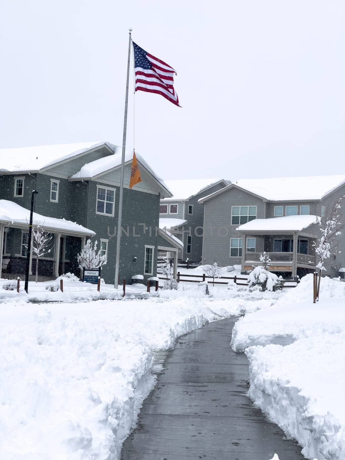 Castle Rock, Colorado, USA-March 16, 2024-Snow blankets a suburban street, where houses stand in quiet repose and driveways reveal the morning labor against the winter relentless drifts.