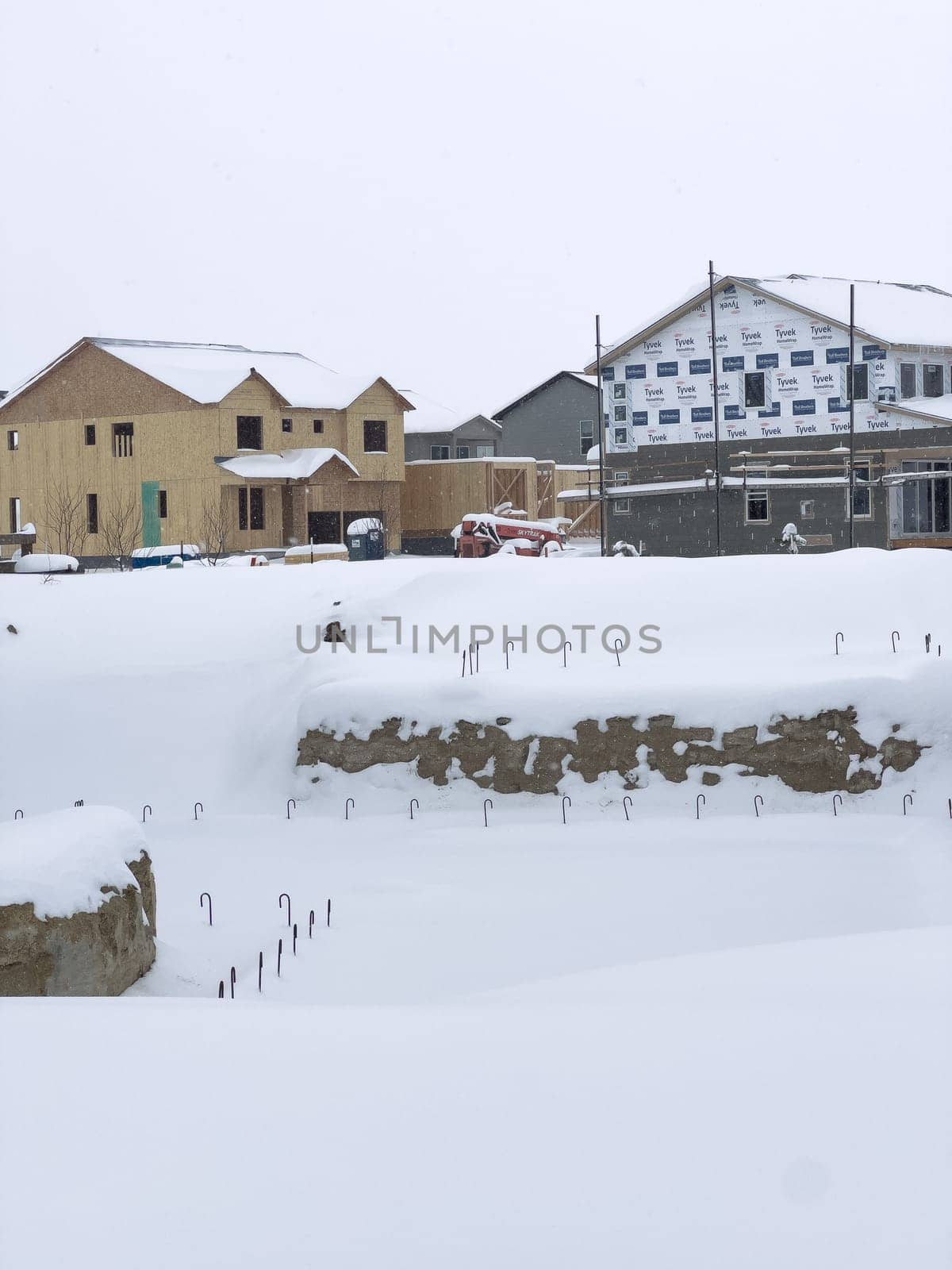 Castle Rock, Colorado, USA-March 16, 2024-Fresh snowfall gently covers a new suburban neighborhood under construction, where the emerging structures await completion, nestled in a wintery setting.