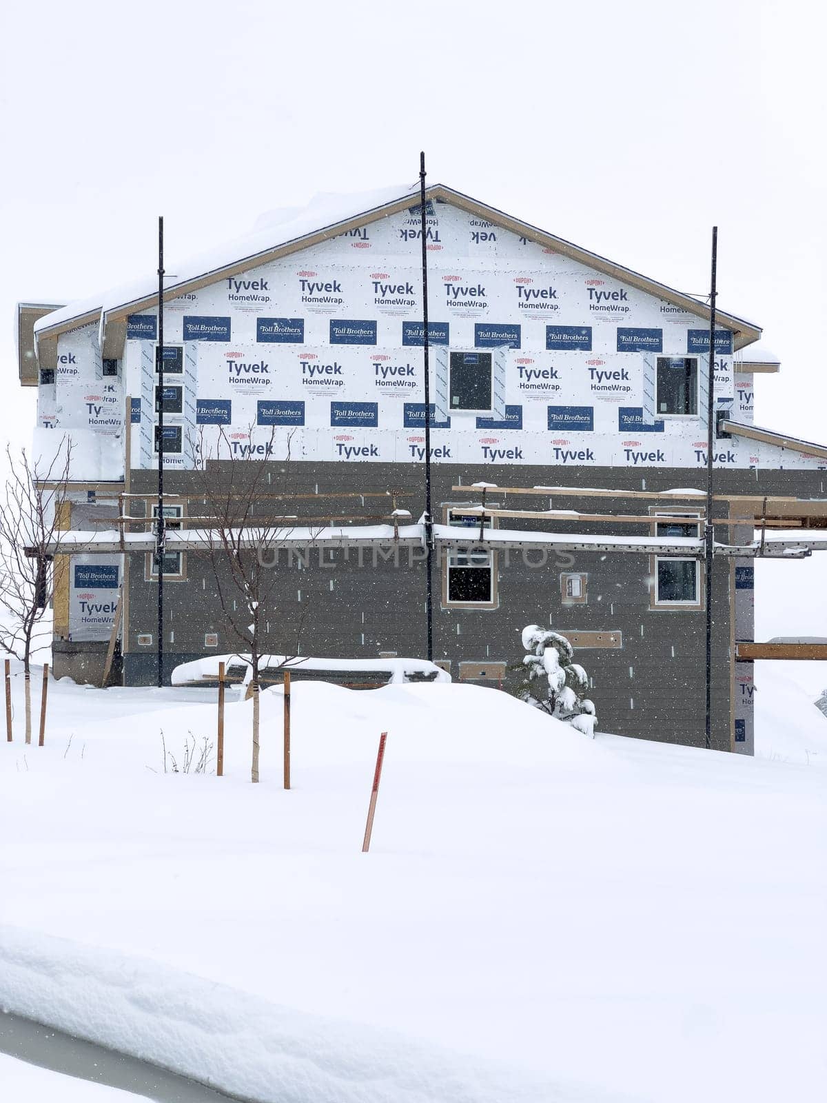 Castle Rock, Colorado, USA-March 16, 2024-Fresh snowfall gently covers a new suburban neighborhood under construction, where the emerging structures await completion, nestled in a wintery setting.