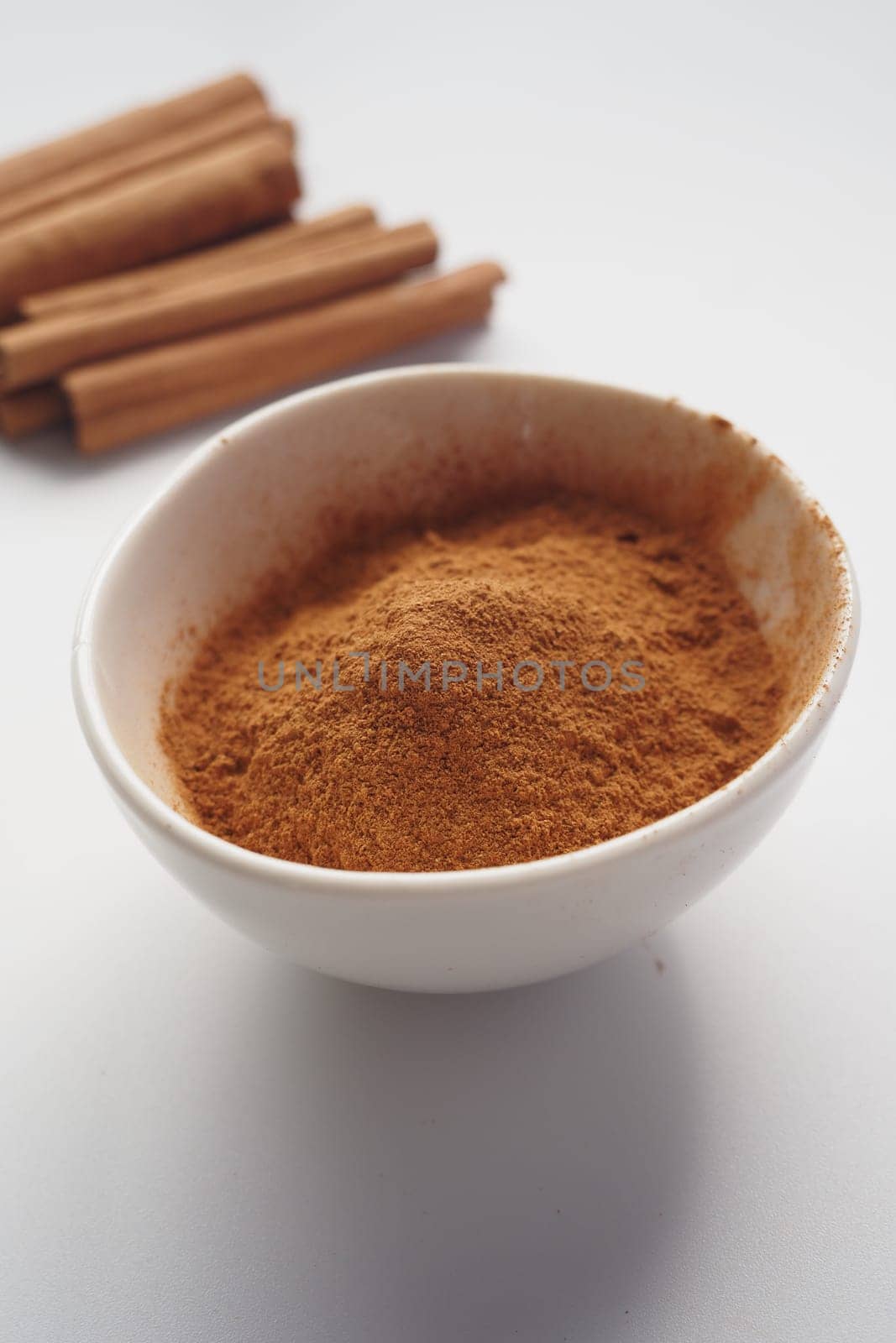 Cinnamon sticks and cinnamon powder on white background