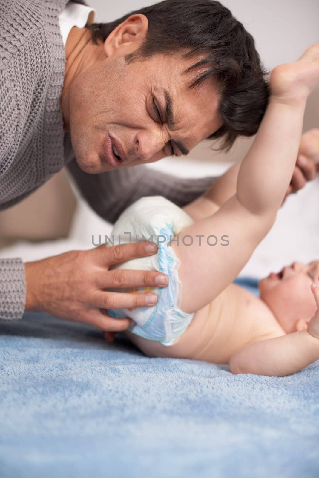 Dirty diaper, smell and father cleaning baby on bed with gross expression or disgust at home, Family, love and dad face with kid in a bedroom for stink napkin, change and cold development routine.