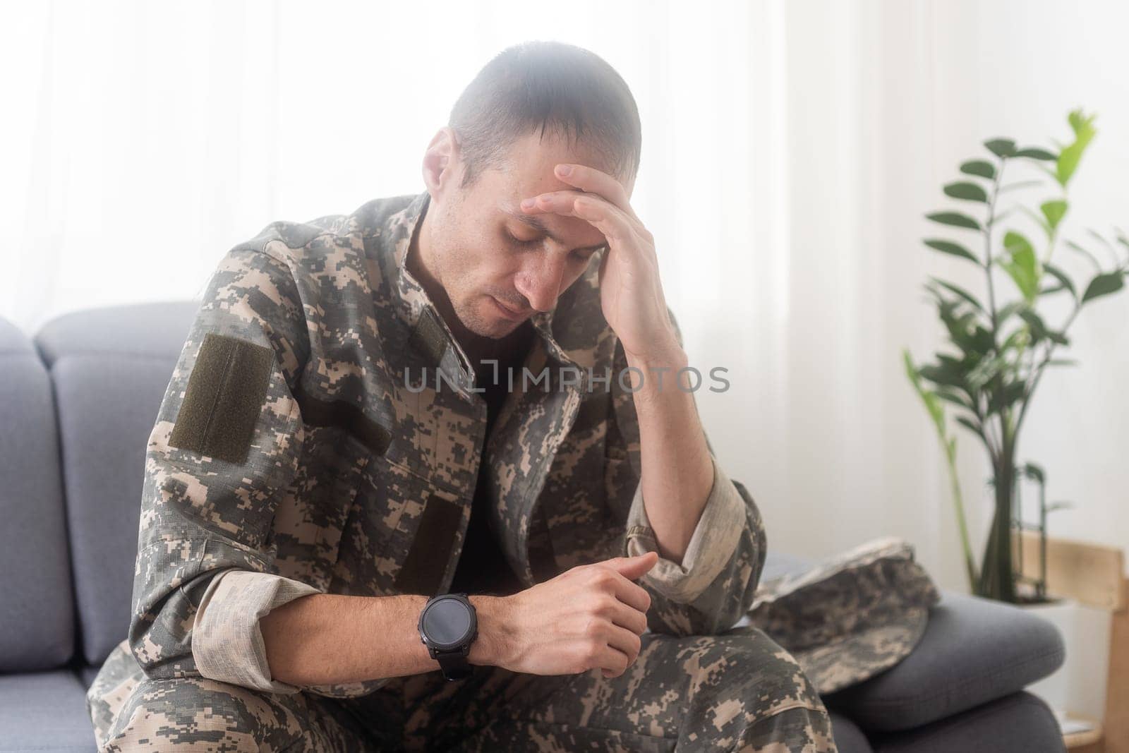 Nervous male military suffering depression, sitting alone at home, PTSD concept by Andelov13