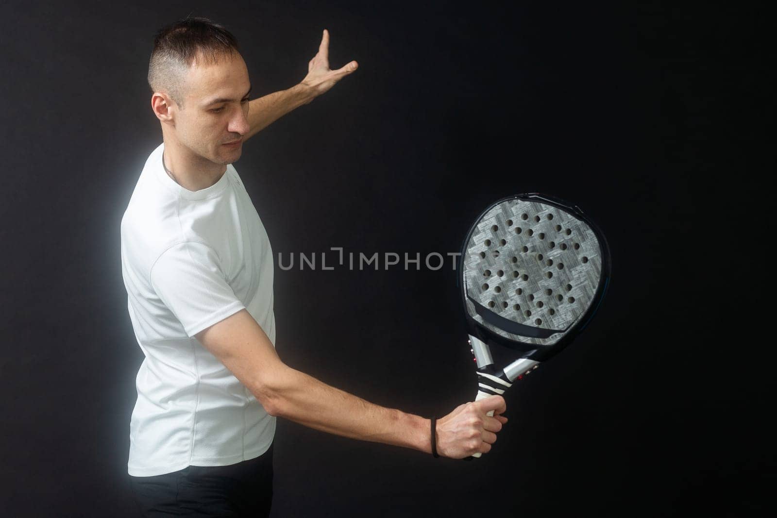 Padel Tennis Player with Racket in Hand. Paddle tennis, on a black background. High quality photo