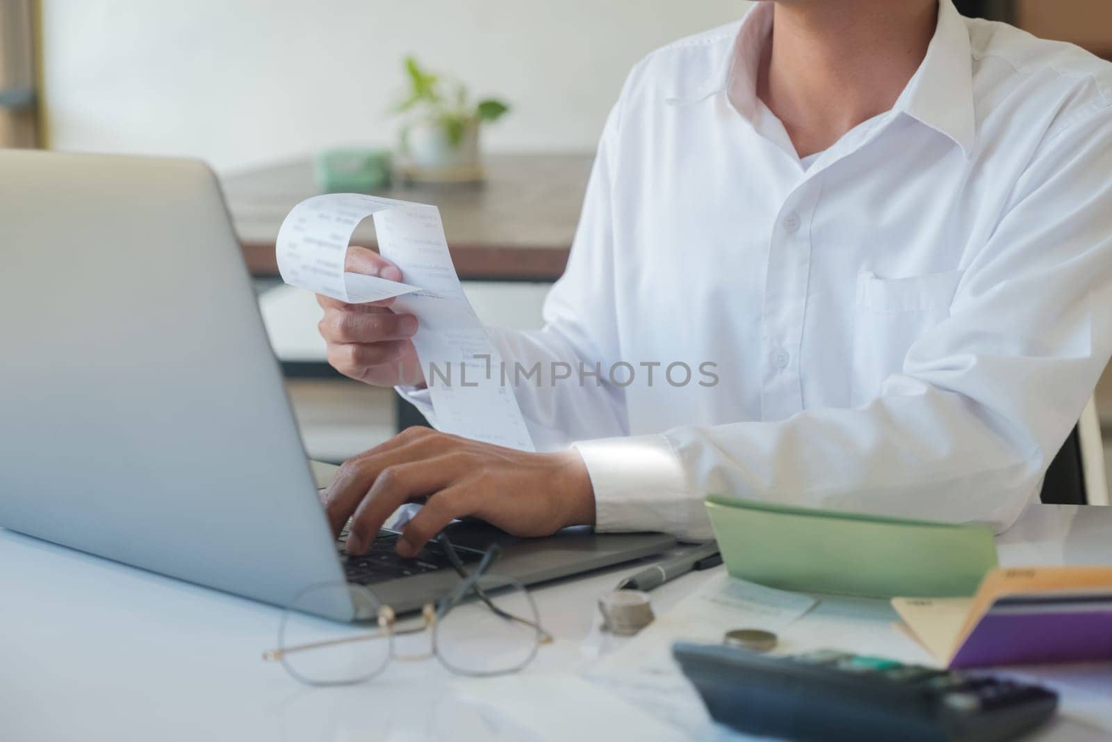An accountant is using a computer to make calculations. and check the accuracy of accounts, calculate taxes, calculate information for investment
