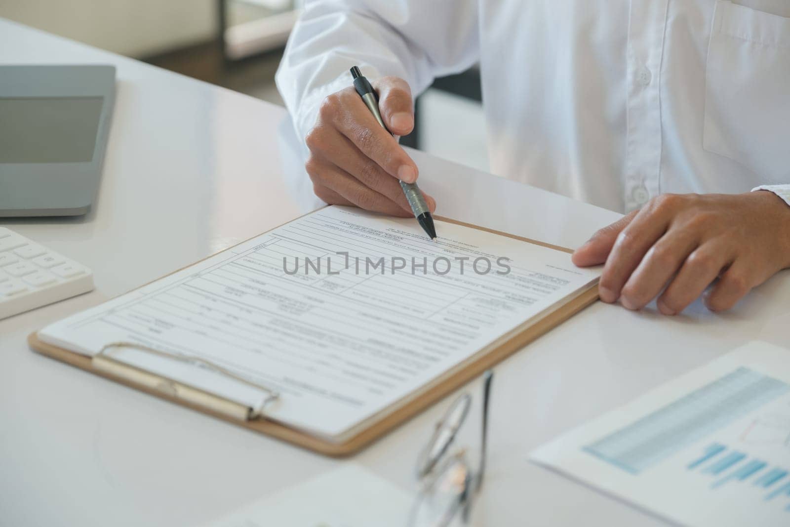 Close up hands of a businessman who is signing a contract document. Business agreement