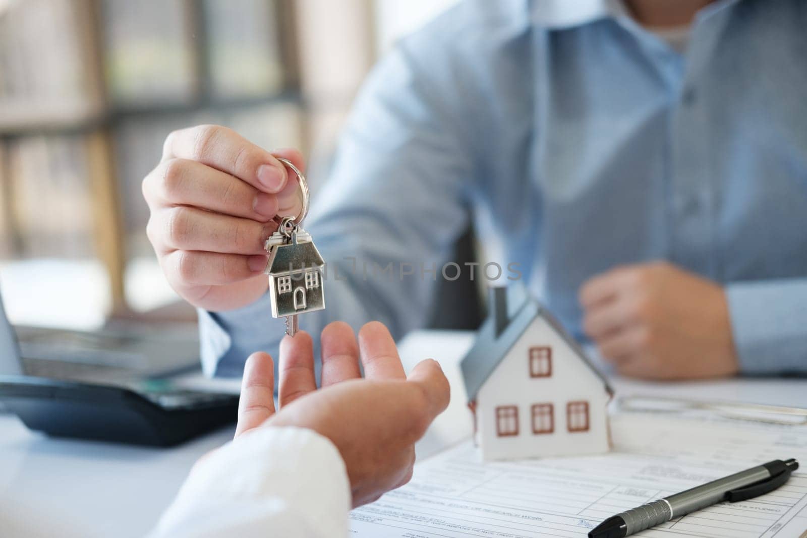 The real estate agent hands the keys to the customer. Real estate investment loans by ijeab