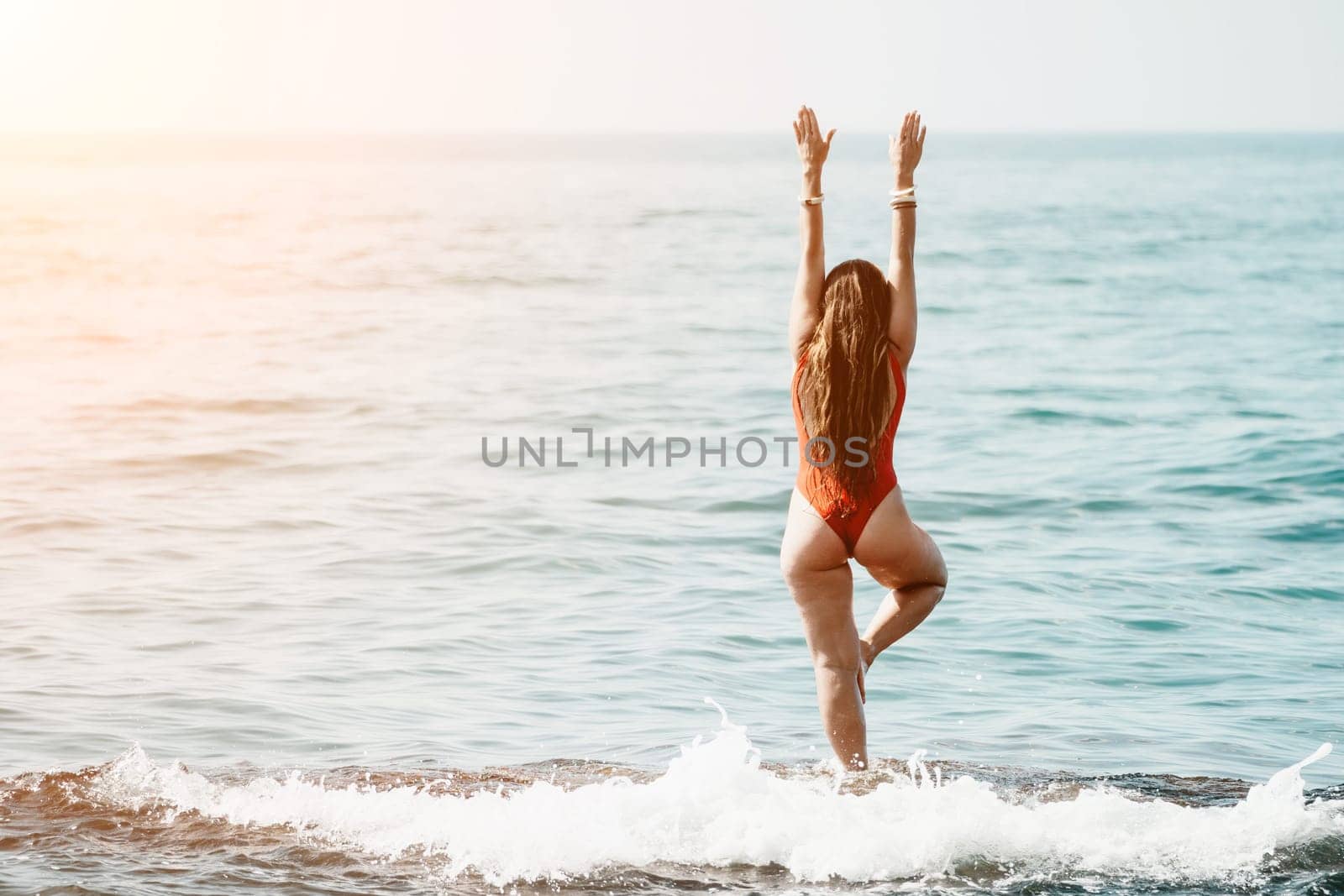 Woman sea yoga. Happy woman meditating in yoga pose on the beach, ocean and rock mountains. Motivation and inspirational fit and exercising. Healthy lifestyle outdoors in nature, fitness concept. by panophotograph