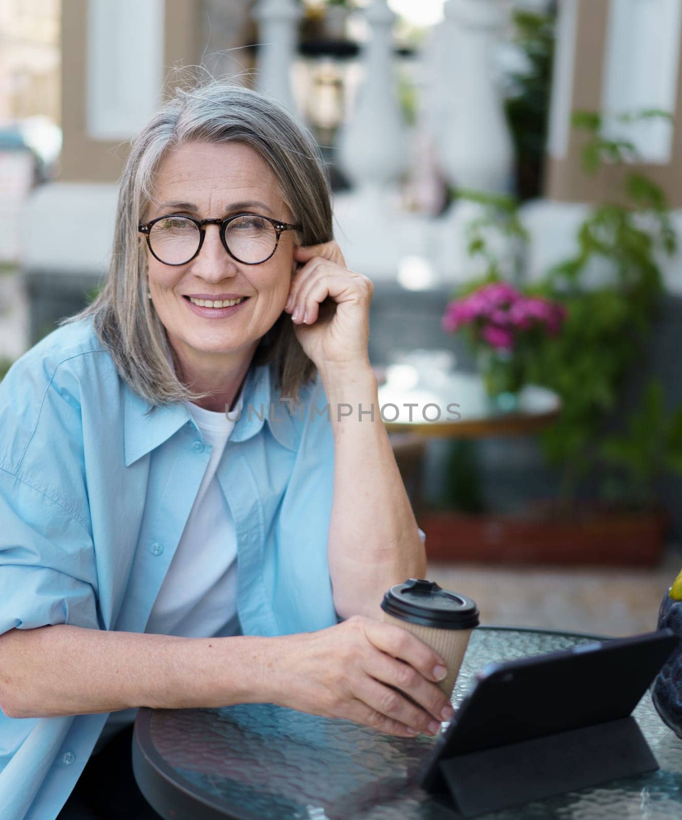 Woman Sitting at Table With Coffee Cup by LipikStockMedia