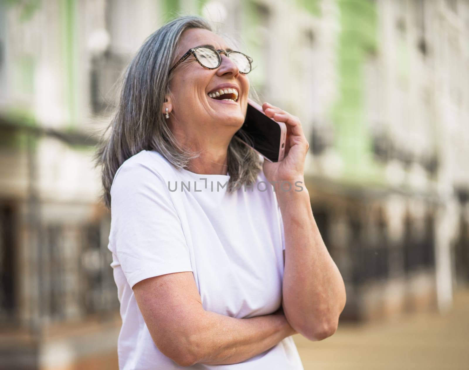 A woman wearing glasses is talking on her cell phone.