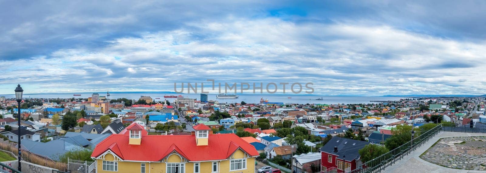 Expansive panoramic view of a colorful coastal town of Punta Arenas by FerradalFCG