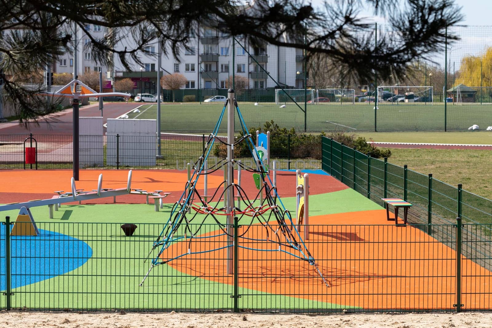 A separate and fenced play area for children with a safe, colorful surface. Children's outdoor playground.