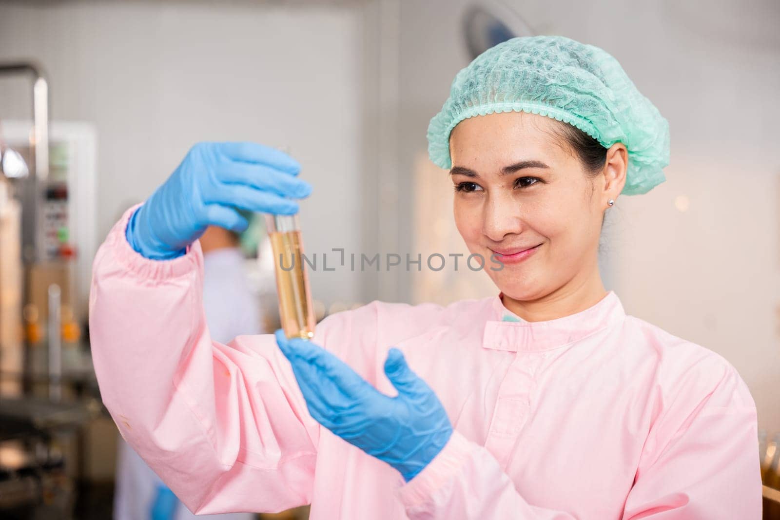 Woman food engineer in juice beverage factory demonstrates food and beverage quality and safety testing by utilizing test tubes for sampling basil or chia seeds in bottled drinks expertise.