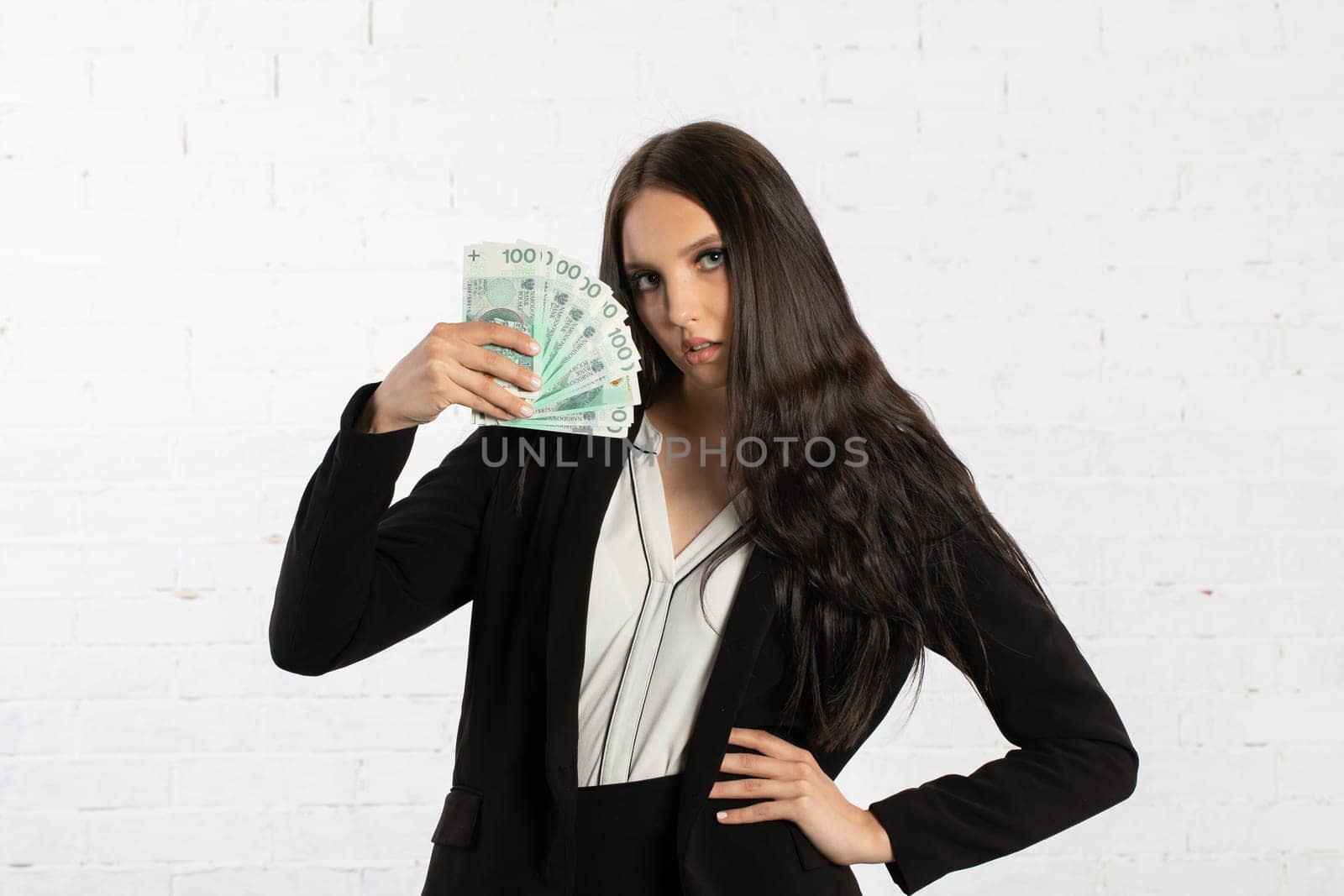 A young successful woman is holding a large amount of cash.