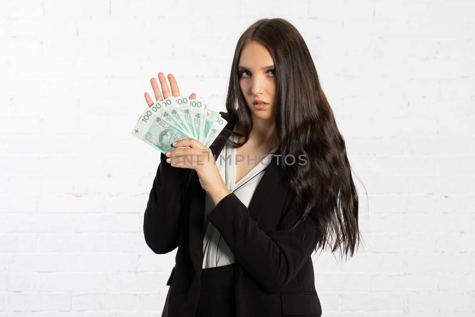 A young successful woman is holding a large amount of cash.