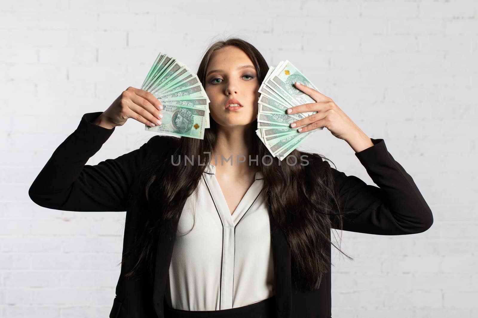 A young successful woman is holding a large amount of cash.