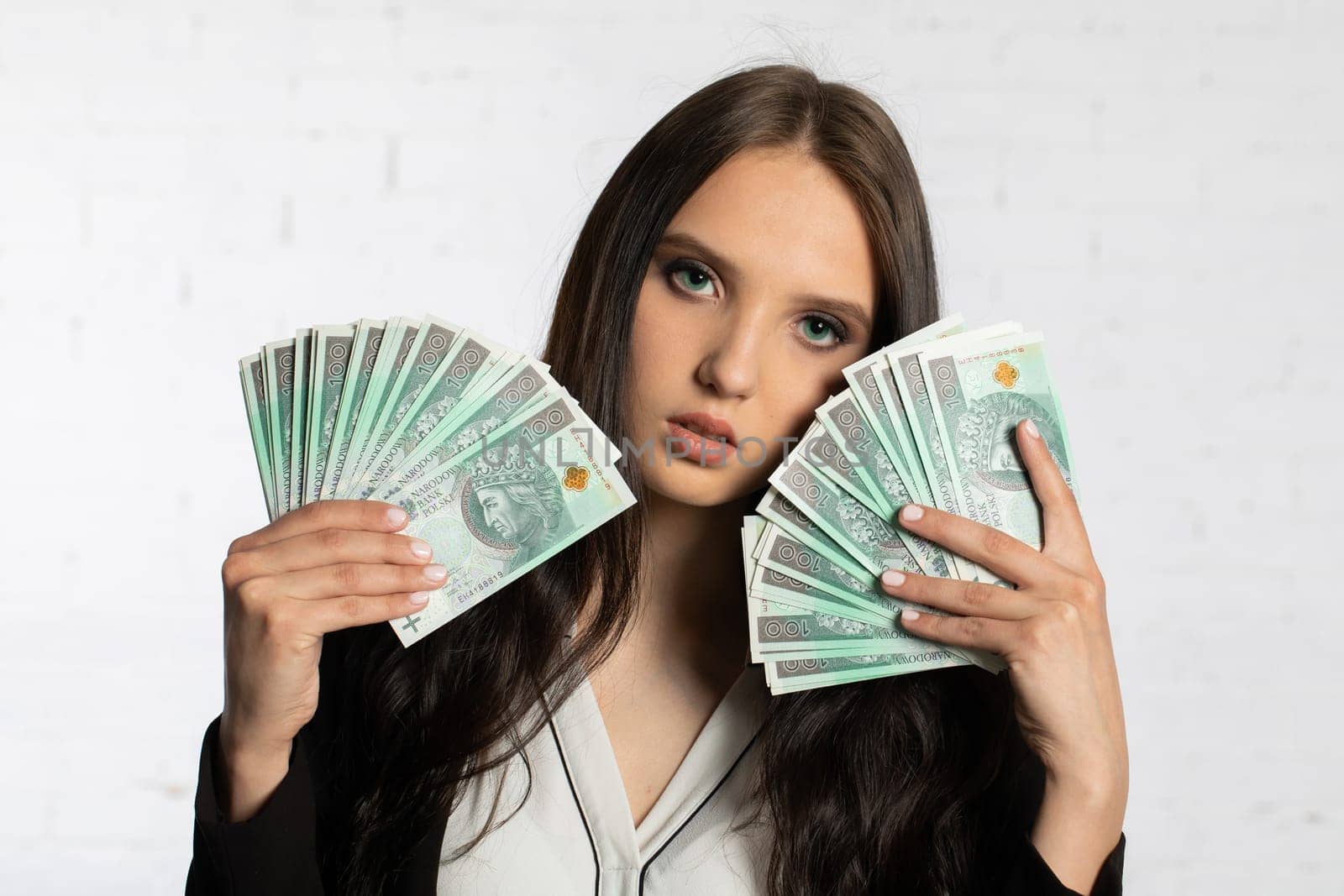 A young successful woman is holding a large amount of cash.