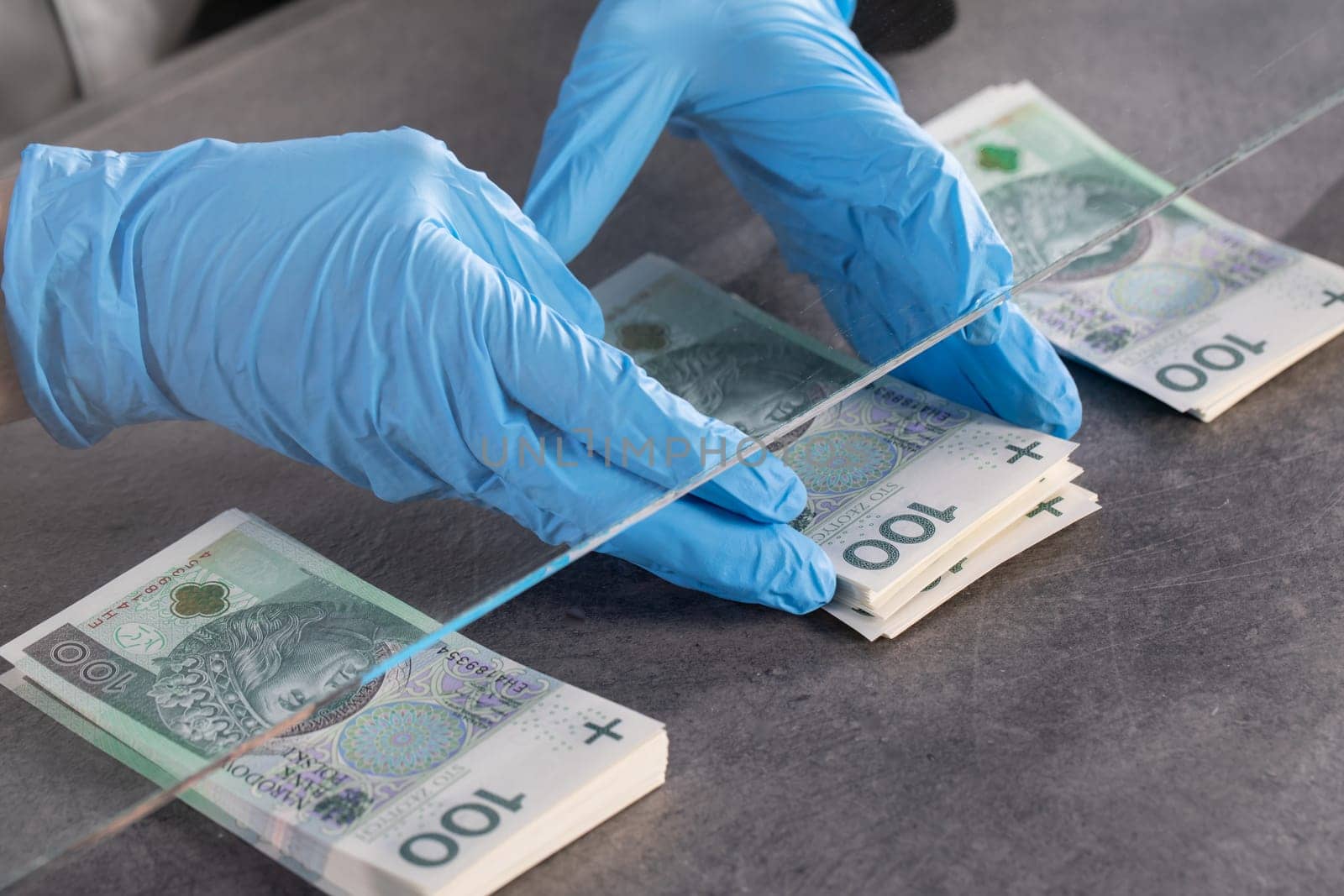 During an ongoing epidemic of infectious disease, the cashier gives cash in protective gloves.