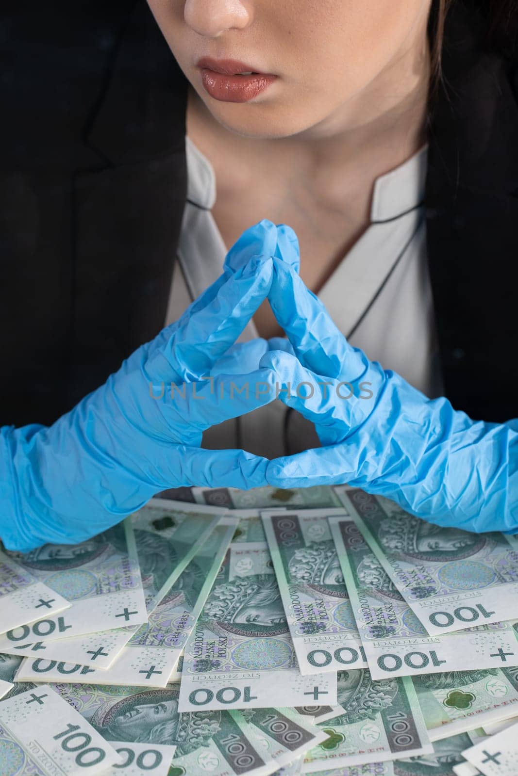 The cashier has randomly distributed banknotes on the desk behind the glass and tries to count them all exactly.