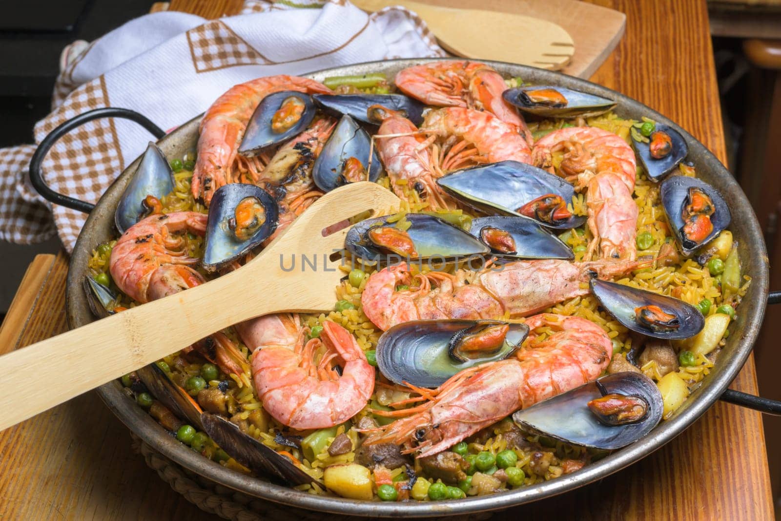 Close-up of shrimp and mussel paella in a pan with a wooden spatula, typical Spanish cuisine, Majorca, Balearic Islands, Spain,