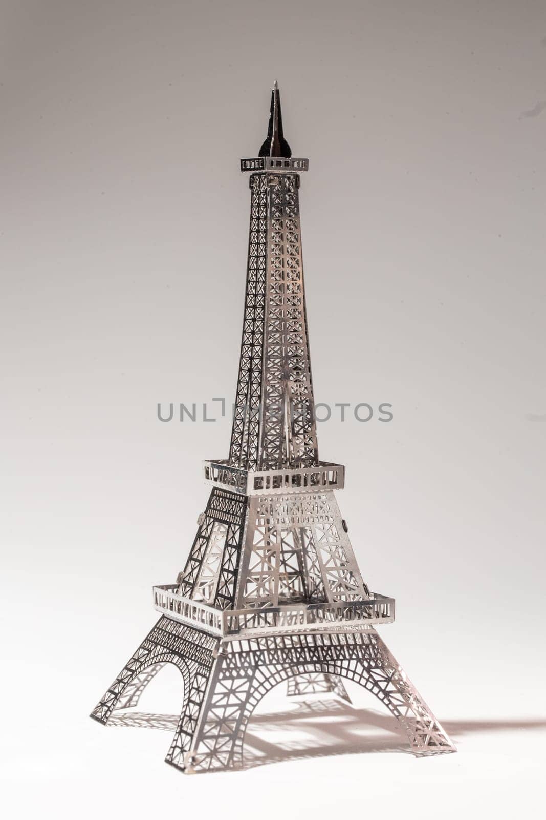 Delicate metal Eiffel Tower model on white background by Pukhovskiy