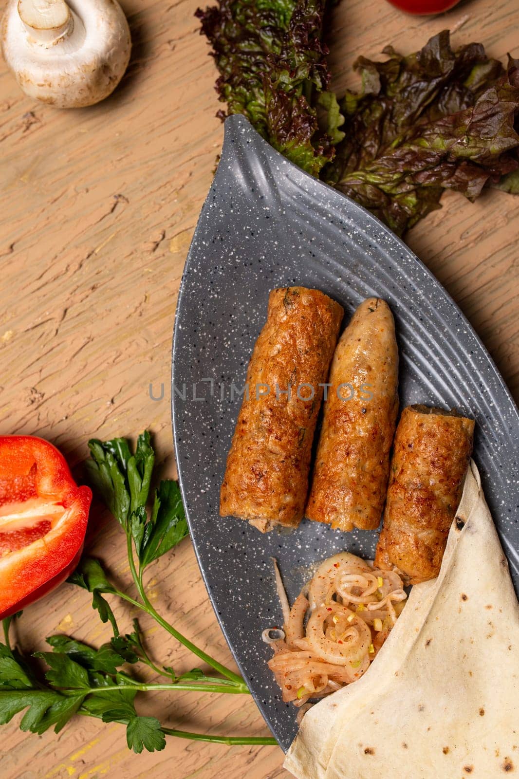 Top view Chicken Kebab Skewers with Grilled Vegetables and Fresh Herbs on Wooden Table by Pukhovskiy