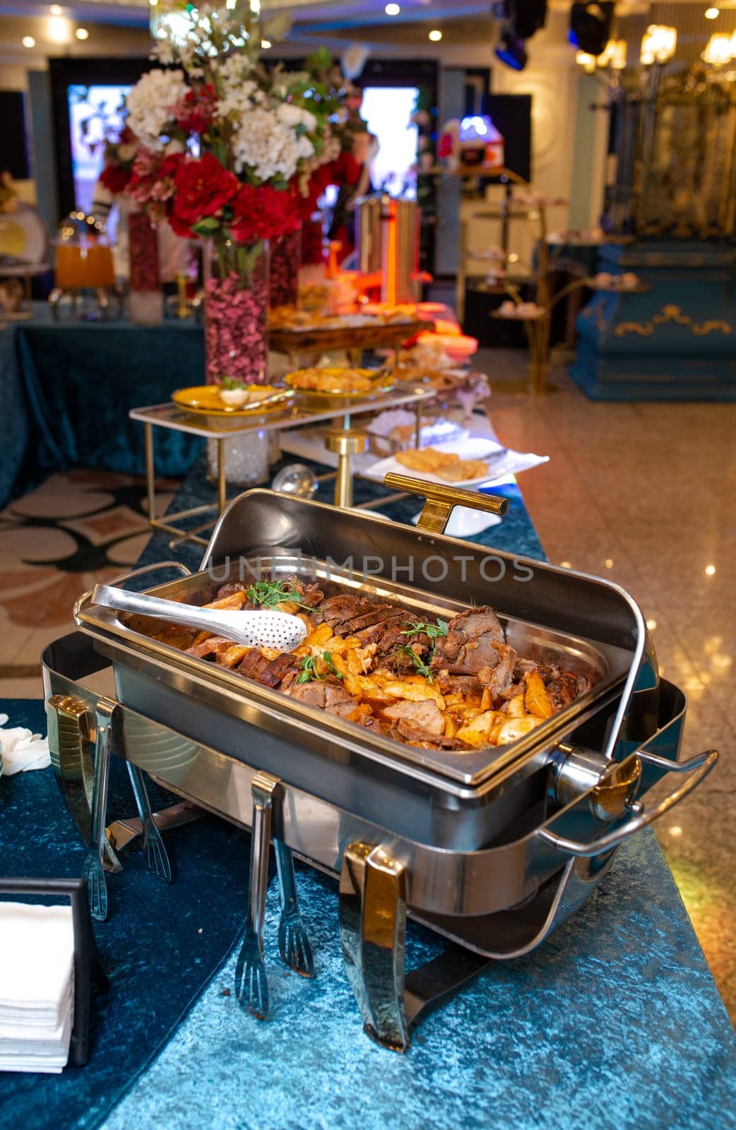 A buffet food warmer filled with delicious beef. The beef is cooked to perfection and is served with a variety of sauces and sides.