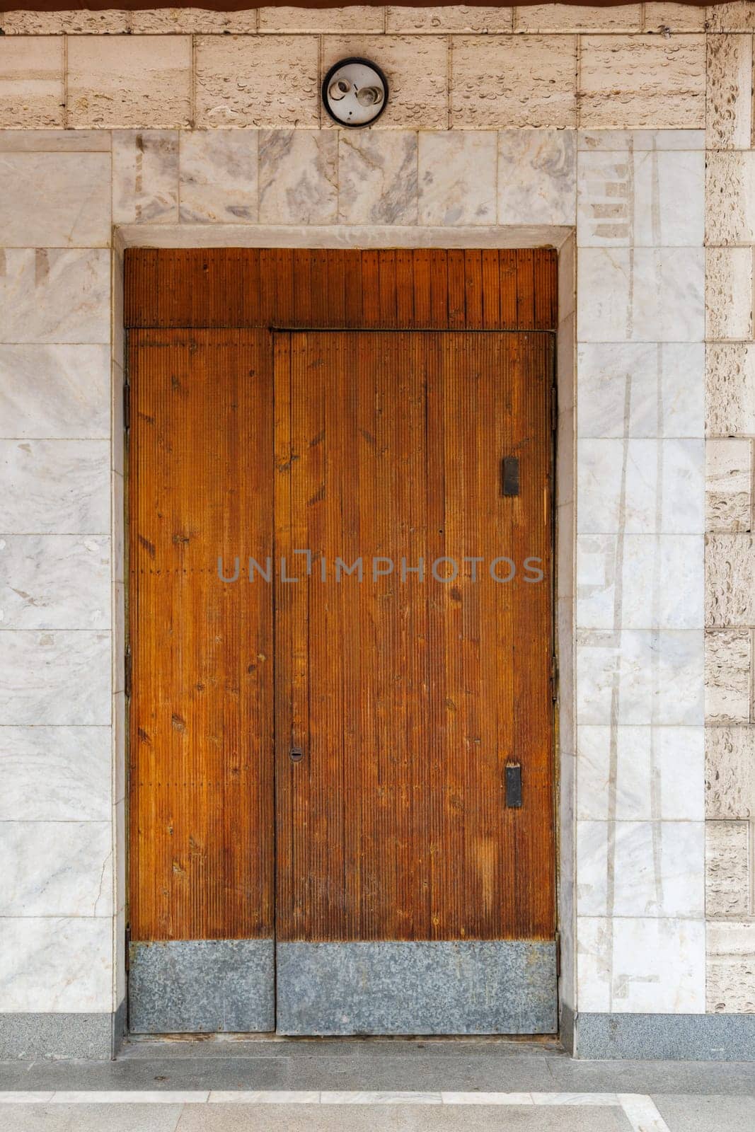 old wooden door of soviet public building in a wall made of shell rock and marble by z1b