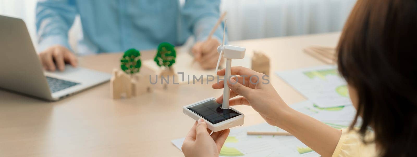 Businesswoman interested in investing in renewable energy at meeting table with environmental document scatter around. Business team discussion about green business project. Closeup. Delineation.
