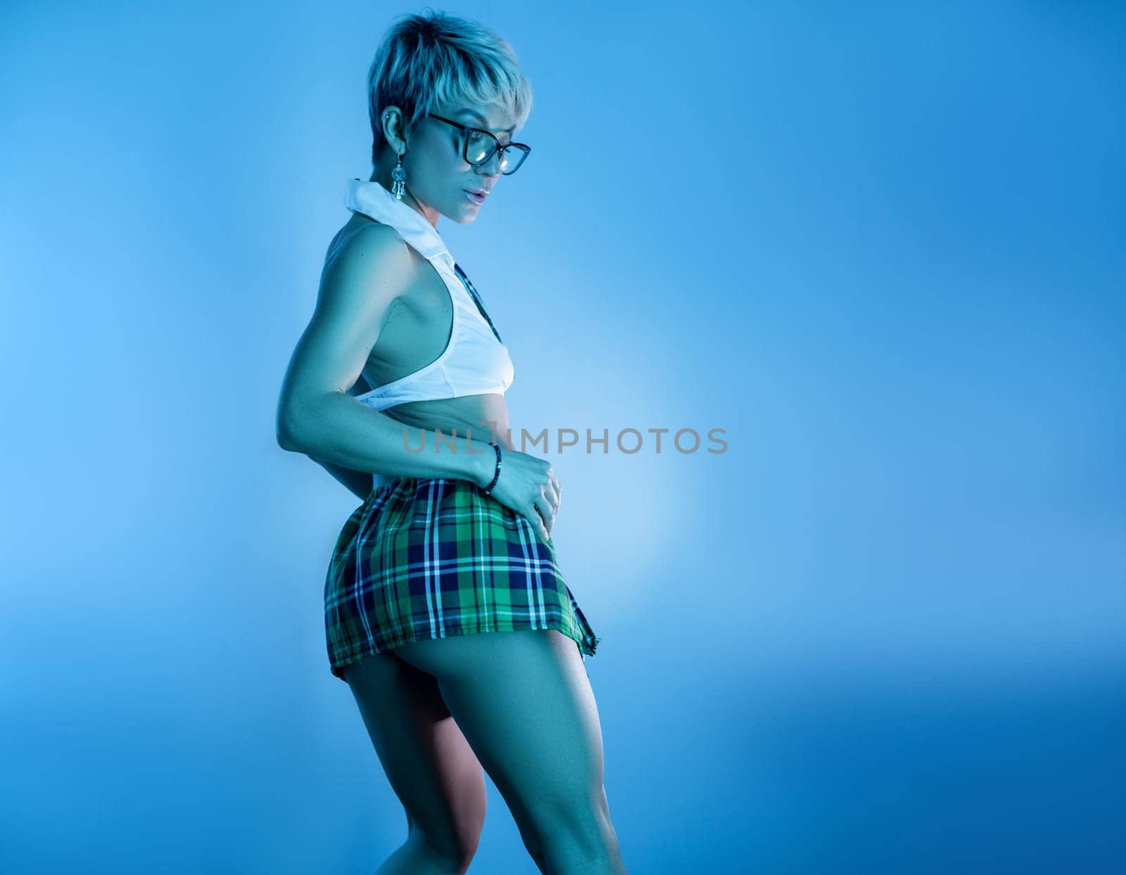 Sexy girl in an erotic school plaid skirt costume from a sex shop in blue neon light on a copy paste background by Rotozey