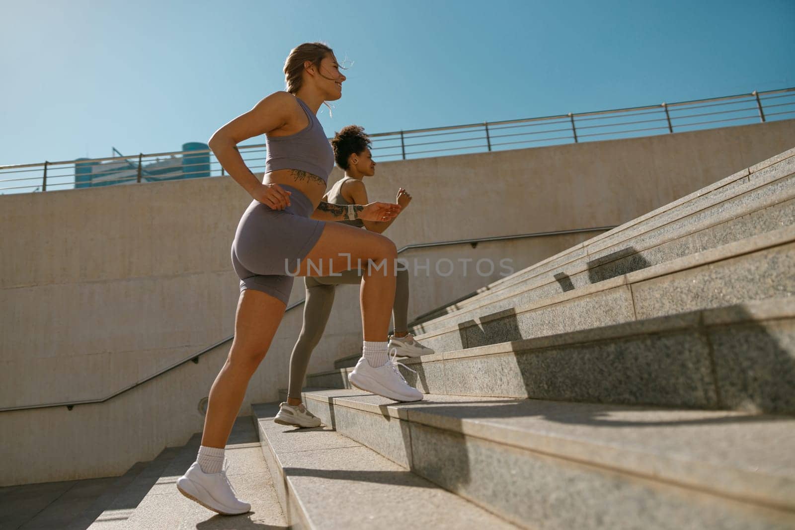 Side view of athletic women in sportswear are jogging around the city in morning. Reaching the goal