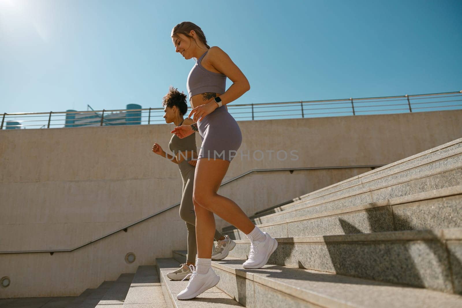 Side view of athletic women in sportswear are jogging around the city in morning. Reaching the goal by Yaroslav_astakhov