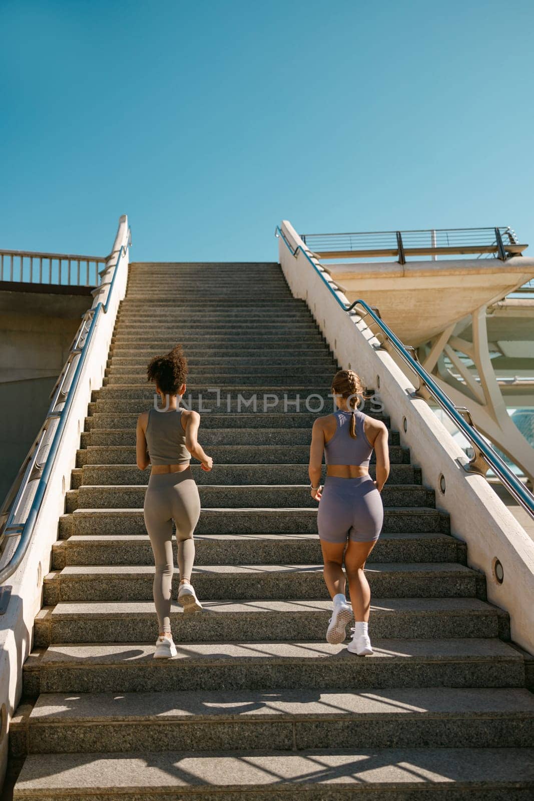 Back view of athletic women in sportswear are jogging around the city in morning. Reaching the goal by Yaroslav_astakhov